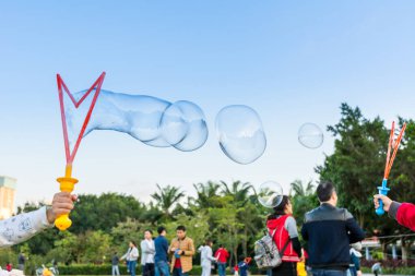 Longtan Park, Shenzhen, Çin 'de sabun köpüğüyle oynayan Çinli küçük kız.