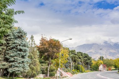 Tahran Uluslararası Sergi Merkezi 'nde kış Tahran sokak manzarası Alborz Dağları karla kaplı arka planda bulutlu gökyüzü