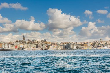 İstanbul 'daki Karaköy' de antik Galata kulesi binalarının bulunduğu Altın Boynuz Kenti, arka plandaki Boğaz 'dan bulutlu gökyüzüne uzanır.