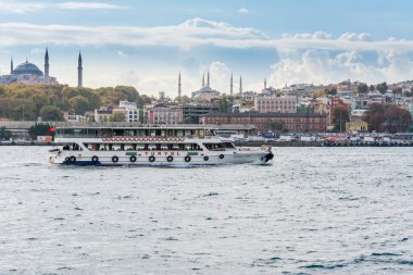 Güneşli bir günde İstanbul 'da İstanbul Boğazı' ndan kalkan antik ve modern binalarla Altın Boynuz 'da seyahat eden gemi.  