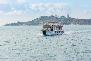 Güneşli bir günde İstanbul, İstanbul ve Türkiye 'nin arka plan bulutlu gökyüzü ile İstanbul Boğazı' nda turist gezisi