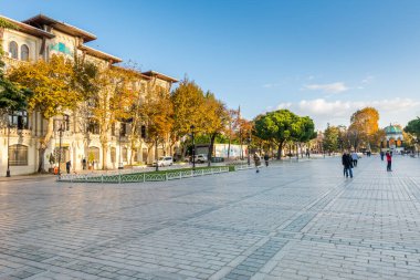 İstanbul Hipodromu 'ndaki bir sıra ağaç da İstanbul, Türkiye' de sonbaharda sabah saatlerinde altın güneş ışığı altında Sultan Ahmet Meydanı 