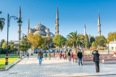  Sultan Ahmet Camii veya Sultan Ahmet Camii olarak da anılan Mavi Cami 'yi ziyaret eden turistler, sonbaharda sabah saatlerinde İstanbul, Türkiye' de güneş ışığı altında ziyaret ediyorlar.
