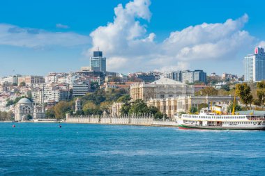 İstanbul Boğazı 'ndaki Dolmabahce Sarayı güneşli bir günde feribottan gökyüzü bulutlu