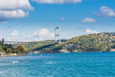 Güneşli bir günde İstanbul, İstanbul 'da arka plan bulutlu mavi gökyüzü ve mavi denizle Boğaz Boğazı' nın arka planına sahip Fatih Sultan Mehmet Köprüsü. Mavi Hindi konsepti.