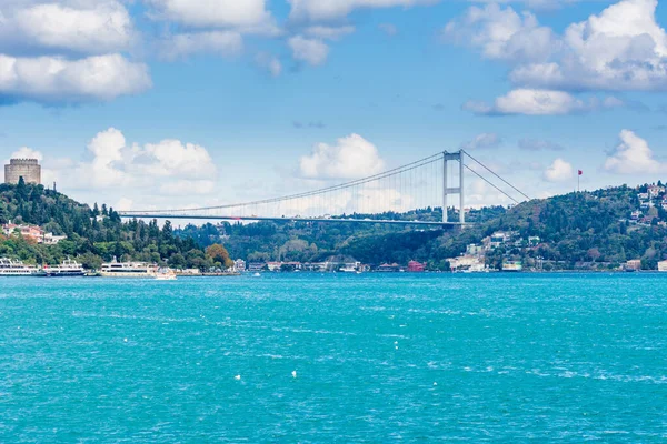 Çağdaş yapılar ve Rumeli Kalesi ve İstanbul Boğazı 'ndaki Fatih Sultan Mehmet Köprüsü güneşli bir günde arka planda bulutlu gökyüzü ile feribottan Türkiye' ye iniyor.