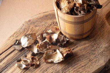 Tahta bir tahtanın üzerinde ahşap fıçıda kurutulmuş Porcini mantarları..