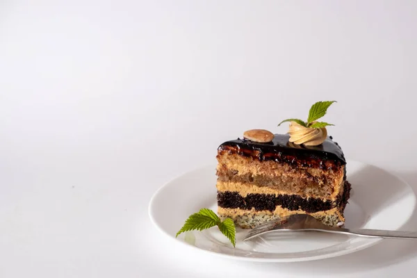 Piece of chocolate cake on a plate close-up isolated on a white background. — Stock Photo, Image