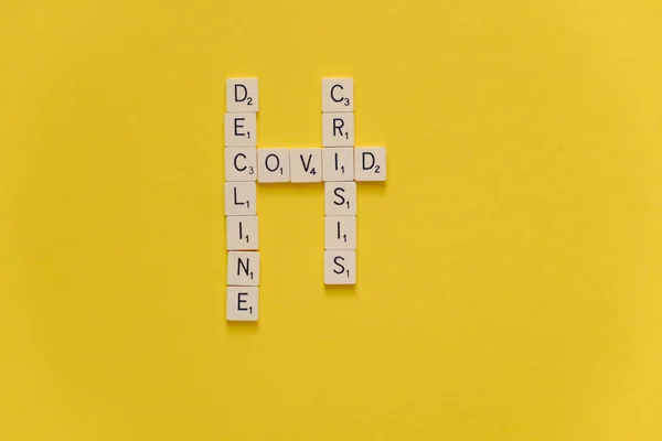 Covid Crisis Decline. Word crossword scrabble game on a yellow background. Copy space. — Stock Photo, Image