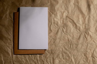 Buruşuk bej arka planda boş bir tebrik kartı. Üst manzara, düz yatış. Kopyalama alanı