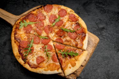 Siyah desenli arka planda Pepperoni Pizza. Mozzarella peyniri, salam ve roka. en üstteki görünüm ve kopyala