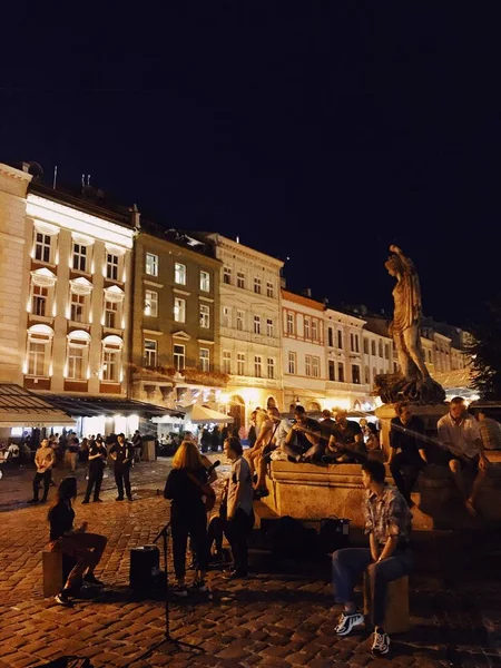 Lwów, Ukraina, sierpień 2019. Uliczni muzycy grają na centralnym placu miasta. Piękne miasto wieczorne. — Zdjęcie stockowe