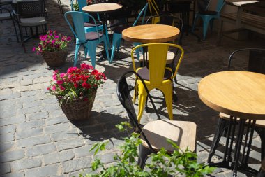 Lviv street cafe - multi-colored metal chairs, tables and flowers.
