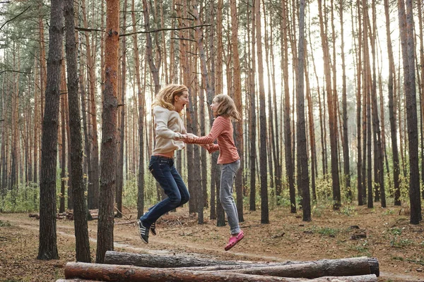 Киев, Украина, сентябрь 2020 г. Мать и дочь веселятся на природе. Они прыгают в лес. Концепция счастливой семьи — стоковое фото
