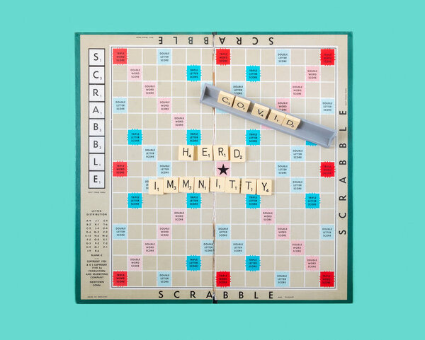 Львов, Украина, июнь 2021 года. Игровая доска для скраббла. Классическая американская игра. Концепция стадного иммунитета против ковида-19.