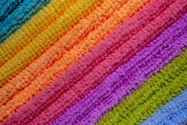 Bir yığın renkli mikrofiber peçete. Bir sıra çapraz renkli mikrofiber havlu. Tam çerçeve. 