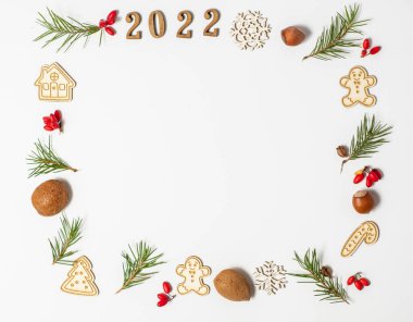 Noel aralığı. 2022 numaranın düzlüğü, köknar dalları, kırmızı böğürtlen, beyaz arka planda yeni yıl oyuncakları. Düz yat ve boşluğu kopyala
