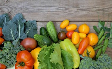 Ahşap bir arka planda birçok farklı renkli sebzeler. Hasat ve yaz mevsimi konsepti.