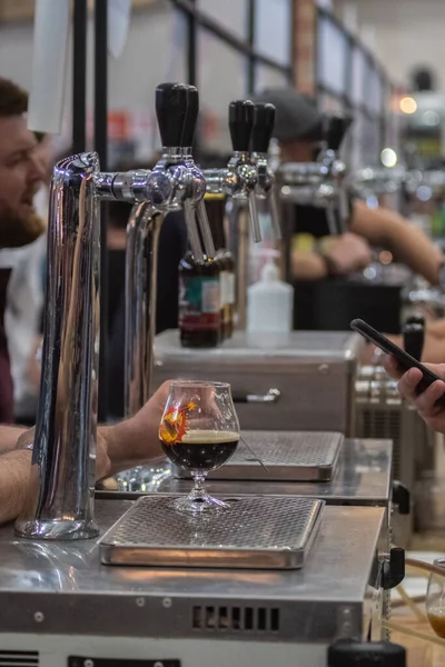 September 2021, Lviv, Ukraine, craft beer and vinyl festival. Caucasian people faceless drink craft beer from branded glasses