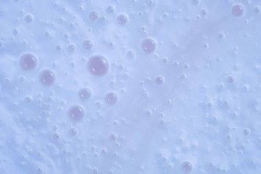 Abstract macro of pastel blue surface densely covered with clusters of pinkish translucent bubbles. The arrangement is soft and dreamy, offering visual interest, copy space 