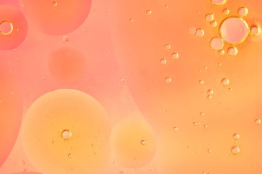 Orange peach abstract bubbles in liquid, macro. Different-sized clear bubbles float on a saturated orange background. Clean, warm composition, horizontal format, bright and modern