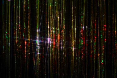 Parlak gümüş Noel süsleri ve renkli yansımalı sicim ışıkları, dikey şenlik arka planı. 