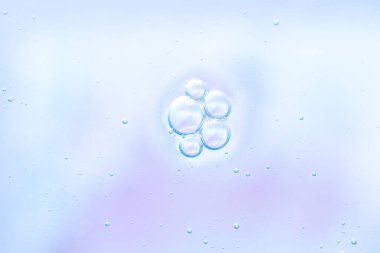 Açık mavi renkli arka planda hava kabarcıklarının temiz makro fotoğrafı. Bilim, cilt bakımı, medikal ve modern dijital tasarım için mükemmel, taze ve serin tonlara sahip soyut minimal doku.