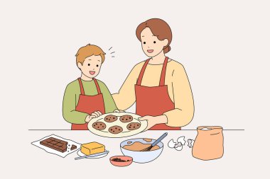 Beyaz Anne Oğlu Kurabiye Pişiriyor tezgahın üstünde Hamur 'u Yuvarlanan Pin, Un lekeli önlükler, Kâselerle Karıştırıyor