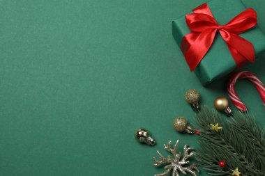 Paketlenmiş hediyeler, şekerler ve süslemelerle dolu şenlik sahnesi, bazen yeşil bir arka planda, Noel tebriklerini iletiyor ve kutluyor.