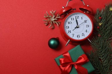 Paketlenmiş hediyeler, şekerler ve süslemelerle dolu şenlik sahnesi, bazen parlak kırmızı bir arka planda, Noel tebrikleri ve kutlamalar iletiliyor