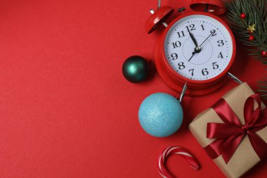 Paketlenmiş hediyeler, şekerler ve süslemelerle dolu şenlik sahnesi, bazen parlak kırmızı bir arka planda, Noel tebrikleri ve kutlamalar iletiliyor