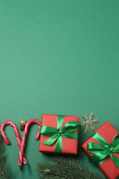 Paketlenmiş hediyeler, şekerler ve süslemelerle dolu şenlik sahnesi, bazen yeşil bir arka planda, Noel tebriklerini iletiyor ve kutluyor.