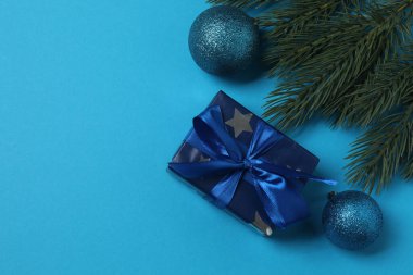 Süslemeli Noel hediyeleri ve mavi arka planda köknar dallarının üst görünümü