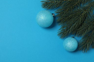 Süslemeli Noel hediyeleri ve mavi arka planda köknar dallarının üst görünümü