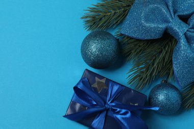 Süslemeli Noel hediyeleri ve mavi arka planda köknar dallarının üst görünümü