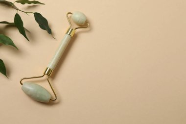 Yüz masajı aleti. Bej bir arka planda kuvars yeşim silindiri.