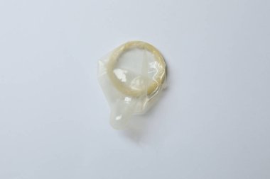 Beyaz zemin üzerinde bir prezervatifin yakın plan, kare ve dikdörtgen paketler beyaz arkaplan üzerinde (yetişkin içeriği) - kırpma yolu.