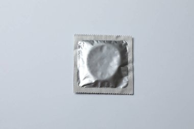 Beyaz zemin üzerinde bir prezervatifin yakın plan, kare ve dikdörtgen paketler beyaz arkaplan üzerinde (yetişkin içeriği) - kırpma yolu.