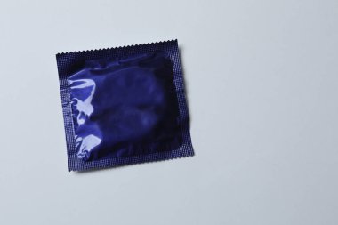 Beyaz zemin üzerinde bir prezervatifin yakın plan, kare ve dikdörtgen paketler beyaz arkaplan üzerinde (yetişkin içeriği) - kırpma yolu.