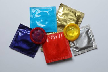 Beyaz zemin üzerinde bir prezervatifin yakın plan, kare ve dikdörtgen paketler beyaz arkaplan üzerinde (yetişkin içeriği) - kırpma yolu.