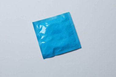 Beyaz zemin üzerinde bir prezervatifin yakın plan, kare ve dikdörtgen paketler beyaz arkaplan üzerinde (yetişkin içeriği) - kırpma yolu.