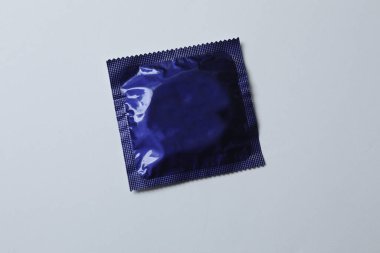 Beyaz zemin üzerinde bir prezervatifin yakın plan, kare ve dikdörtgen paketler beyaz arkaplan üzerinde (yetişkin içeriği) - kırpma yolu.