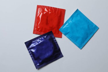 Beyaz zemin üzerinde bir prezervatifin yakın plan, kare ve dikdörtgen paketler beyaz arkaplan üzerinde (yetişkin içeriği) - kırpma yolu.