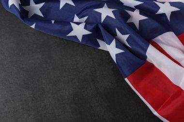 ABD 'de İşçi Bayramı' nı temsil eden beton bir yüzey üzerinde iş eldivenleri, aletler ve Amerikan bayrağı.