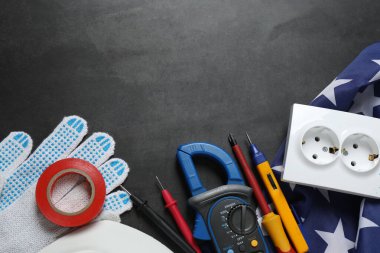 ABD 'de İşçi Bayramı' nı temsil eden beton bir yüzey üzerinde iş eldivenleri, aletler ve Amerikan bayrağı.