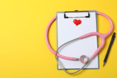 Tıbbi steteskop, kırmızı kalp ve kardiyogram. EKG, nabız, kalp damar tıkanıklığı, kardiyogram. Kardiyogramdaki darbe izi ve kalp konsepti. Sağlık hizmeti. Metin için boşluk