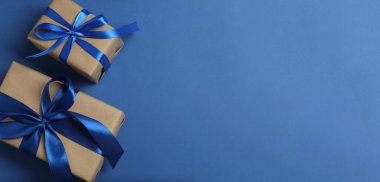 Mavi arka planda süslemeleri olan Noel hediyelerinin üst görünümü