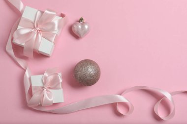 Pembe arka planda süslemeleri olan Noel hediyelerinin en üst görüntüsü