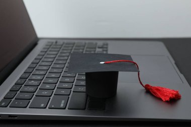 Mezuniyet konsepti. Diploma ve beyaz arkaplan üzerine kitap içeren düz kare akademik başlık.