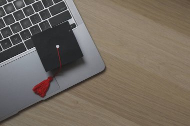 Mezuniyet konsepti. Diploma ve beyaz arkaplan üzerine kitap içeren düz kare akademik başlık.